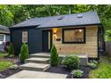 Charming home with dark wood and light wood accent wall, inviting concrete steps, and landscaping at 4245 Norwaldo Ave, Indianapolis, IN 46205
