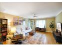 Bright living room featuring hardwood floors, a comfortable white sofa, and natural light from a large window at 526 W Hunters Dr # C, Carmel, IN 46032
