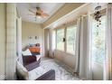 Cozy sunroom with large windows, wicker chairs, neutral rug, and a ceiling fan for relaxing at 526 W Hunters Dr # C, Carmel, IN 46032