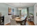 Bright dining room boasts hardwood floors, elegant furniture, and stylish light fixture at 5378 Rosslyn Ave, Indianapolis, IN 46220