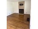 Bright living room featuring gleaming hardwood floors and a modern tiled fireplace at 5378 Rosslyn Ave, Indianapolis, IN 46220