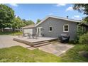 Rear exterior view featuring a wood deck with outdoor seating and gray painted brick at 540 Lazy Ln, Greenwood, IN 46142