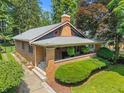 Attractive craftsman-style home with inviting front porch, brick facade, and manicured lawn at 5424 Broadway St, Indianapolis, IN 46220