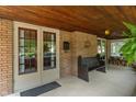 Inviting front porch with wooden ceiling, pew seating, and charming decor details at 5424 Broadway St, Indianapolis, IN 46220