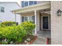 Inviting front porch featuring brick accents and manicured landscaping, creating a cozy entrance to the home at 5859 Edelle Dr, Indianapolis, IN 46237