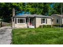 Beautiful stone home with lush green lawn, mature trees, and a paved driveway at 6146 Burlington Ave, Indianapolis, IN 46220