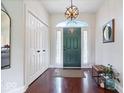 Bright foyer with hardwood floors, closet, stylish light fixture and a green front door at 6528 Fountain Springs Blvd, Indianapolis, IN 46236