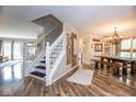 Inviting foyer featuring a staircase and beautiful wood flooring that opens into the dining room at 6532 Amherst Way, Zionsville, IN 46077