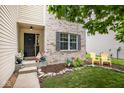 A cute front porch with cheerful decorations and decorative chairs at 6532 Amherst Way, Zionsville, IN 46077