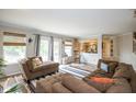 Comfortable living room featuring a large sectional sofa, hardwood floors, and lots of natural light at 6532 Amherst Way, Zionsville, IN 46077