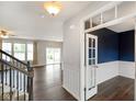 Open-concept living area featuring hardwood floors, abundant natural light, and staircase access at 6670 Shooting Star Dr, Whitestown, IN 46075