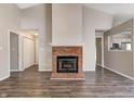 Open floor plan with fireplace, wood flooring, and view into kitchen at 6740 Sundown S Dr, Indianapolis, IN 46254