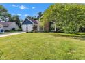 Charming blue two-story home featuring a brick chimney, two-car garage, and a lush green lawn at 8140 Bold Forbes Ct, Indianapolis, IN 46217