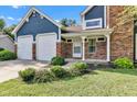 Charming blue two-story home with a brick exterior, a two-car garage and a covered front entrance at 8140 Bold Forbes Ct, Indianapolis, IN 46217