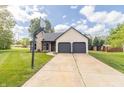 Charming home with attached two-car garage, basketball hoop on the driveway, and nicely manicured lawn at 8925 Sunburst Cir, Indianapolis, IN 46227
