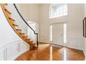 Grand foyer with hardwood floors, a curved staircase, and large windows that flood the space with natural light at 9237 Rocky Cay Ct, Zionsville, IN 46077