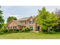 Charming brick home with manicured lawn, lush landscaping and mature trees creating a warm and inviting curb appeal at 9237 Rocky Cay Ct, Zionsville, IN 46077