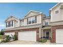 Townhome with brick facade, two-car garage, and inviting entrance, showing the property's curb appeal at 9707 Prairie Smoke Dr, Noblesville, IN 46060