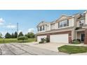 View of townhome with brick accents and garage, highlighting its convenient driveway and outdoor space at 9707 Prairie Smoke Dr, Noblesville, IN 46060