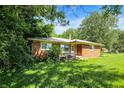 View of a single story brick home with overgrown landscaping and grass on a sunny day at 10159 Hodge Rd, Clayton, IN 46118