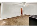 Simple living room with a ceiling fan, dated carpet and an opening into another room at 10159 Hodge Rd, Clayton, IN 46118