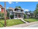 Classic two-story home with a charming front porch, red door, and well-maintained yard at 1105 Windsor St, Indianapolis, IN 46201