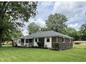Brick home on a large lot with manicured lawn, flowerbeds and covered front porch at 1400 Evelyn Ln, Anderson, IN 46017