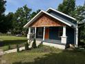 Charming home featuring cedar shake, an orange door, and a covered front porch at 1810 N Parker Ave, Indianapolis, IN 46218