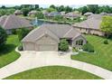 This aerial image showcases the house with a beautiful pond view, green lawn, and big drive way at 182 Southwind Ln, Greenwood, IN 46142