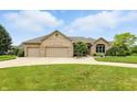 A charming brick home boasts a well-manicured lawn and a spacious three-car garage at 182 Southwind Ln, Greenwood, IN 46142