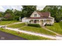 Charming vintage home featuring a welcoming front porch, a well-manicured lawn, and a detached two-car garage at 206 W Wall St, Advance, IN 46102