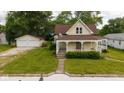Charming vintage home featuring a welcoming front porch, a well-manicured lawn, and a detached two-car garage at 206 W Wall St, Advance, IN 46102
