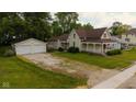 Charming vintage home featuring a welcoming front porch, a well-manicured lawn, and a detached two-car garage at 206 W Wall St, Advance, IN 46102