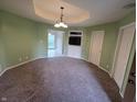 Neutral living room features plush carpeting, modern lighting, and an entertainment center with a built-in TV shelf at 21 Watson Dr, Trafalgar, IN 46181