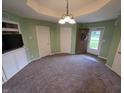 Neutral living room features plush carpeting, modern lighting, and a view into the front yard through the front door at 21 Watson Dr, Trafalgar, IN 46181