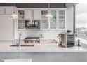 Gourmet kitchen with stainless steel appliances, white cabinetry and marble backsplash at 225 N New Jersey St # 52, Indianapolis, IN 46204