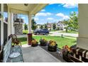Inviting porch with comfortable seating, vibrant floral arrangements, and a view of the neighborhood street at 2282 Creekland Dr, Columbus, IN 47201