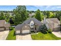 Aerial view of a two-story home with a lush lawn, mature trees, and two-car attached garage at 2463 Kettering Way, Indianapolis, IN 46214