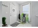 Bright entryway featuring neutral walls, decorative wreath, practical coat rack, and eye-catching houseplants at 2499 Blue Ridge Dr, Greenwood, IN 46143