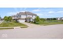 Inviting two-story home with a well-kept lawn, complemented by lush landscaping and a serene pond view at 2499 Blue Ridge Dr, Greenwood, IN 46143