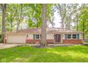 Charming single-story home with brick accents, an attached garage, and a well-manicured lawn at 2613 W Queensbury Rd, Muncie, IN 47304