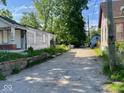 Overgrown backyard, trash cans, and dilapidated fence at 2625 E 12Th St, Indianapolis, IN 46201