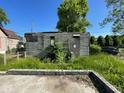 Image of back of a dilapidated house with boarded windows and overgrown grass at 2625 E 12Th St, Indianapolis, IN 46201