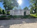 Exterior shot of a dilapidated house with boarded windows and overgrown yard at 2625 E 12Th St, Indianapolis, IN 46201
