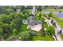 Aerial view of a home with a pool, lush greenery, and a pond nearby at 3399 Nottinghill Blvd, Plainfield, IN 46168