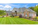 Charming home featuring brick and stone accents, a covered porch, and manicured lawn at 3399 Nottinghill Blvd, Plainfield, IN 46168