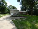 Charming two-story home with a brick and siding exterior, lovely landscaping, and a spacious driveway at 3518 Woodale Rd, Indianapolis, IN 46234