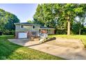 Charming two-story home with a brick and siding exterior, a spacious driveway, and mature trees at 3518 Woodale Rd, Indianapolis, IN 46234