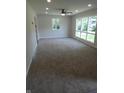 Spacious living room with large windows, neutral paint, new carpet, and a modern ceiling fan at 3518 Woodale Rd, Indianapolis, IN 46234
