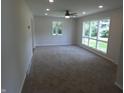 Bright and airy living room with large windows, neutral paint, plush carpet, and modern ceiling fan at 3518 Woodale Rd, Indianapolis, IN 46234